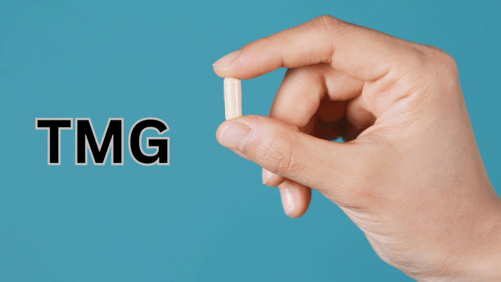 A hand holding a TMG supplement between 2 fingers