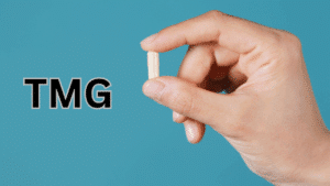 A hand holding a TMG supplement between 2 fingers